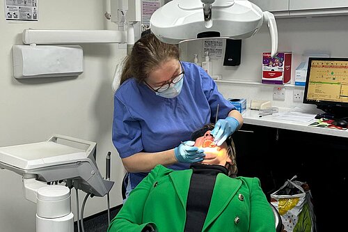 Pippa Heylings lying in a dentists chair while a dentist is inspecting her teeth