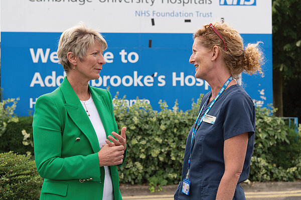 Photo of Pippa Heylings talking with an NHS doctor in front of Addenbrooke's Hospital