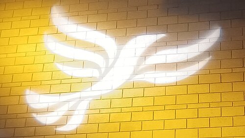 Toxins in Cambridgeshire water supply- Lib Dems demand tougher action Lib Dem logo bird projected on blockwork