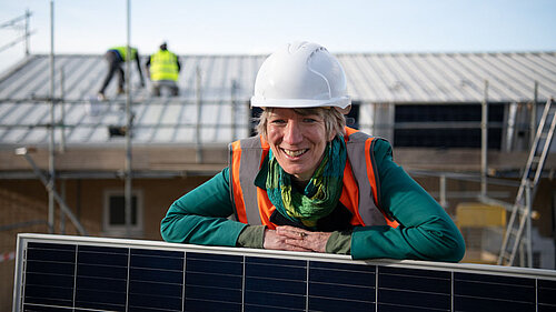 Pippa at a construction site, with solar panels being installed.