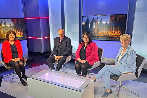 Pippa Heylings in the ITV Anglia Politics studio, sitting next to two other panelists and the presenter