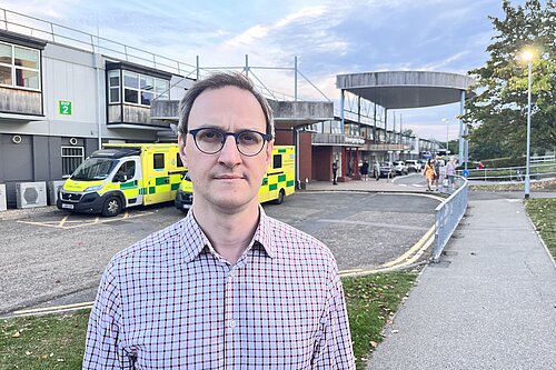 Ian Sollom standing in front of Hinchingbrooke Hospital
